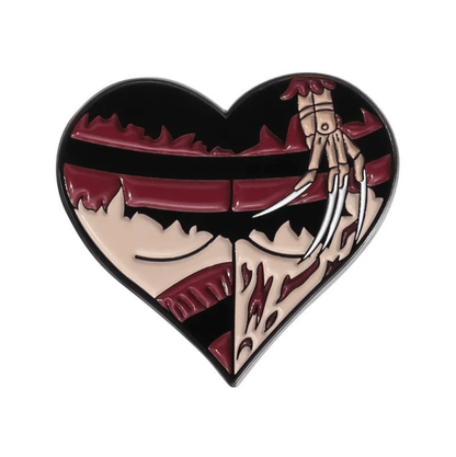 Pin  that is heart-shaped with black and dark red jagged stripes, featuring a gloved hand with metal blades slashing through the heart for a true gothic Freddy Krueger-inspired look.