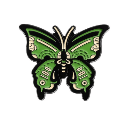 A green and black enamel pin  shaped like a stylized butterfly with cream accents, inspired by the Butterfly Cash Cigarette Box collection, shown on a white background.