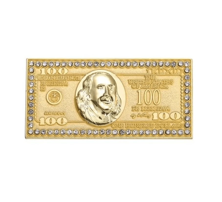 A gold-toned, rectangular piece shaped like a $100 bill with Benjamin Franklin embossed and surrounded by sparkling clear gems—a bold accessory to complement your Red Lips Cash Roll collection.