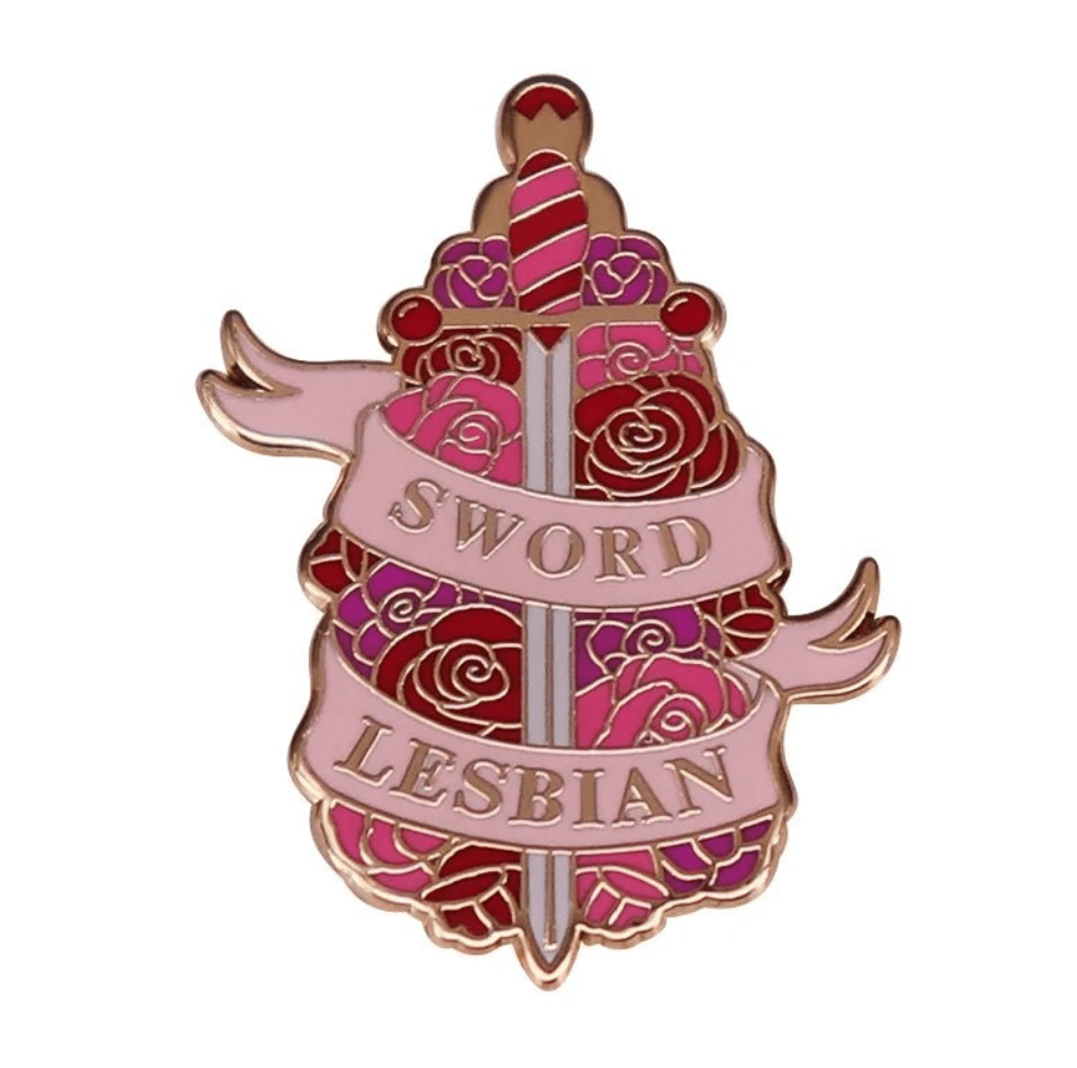 Sword Lesbian pin features a sword with red and purple roses, wrapped in a pink SWORD LESBIAN banner—a vibrant floral badge perfect for any collection.