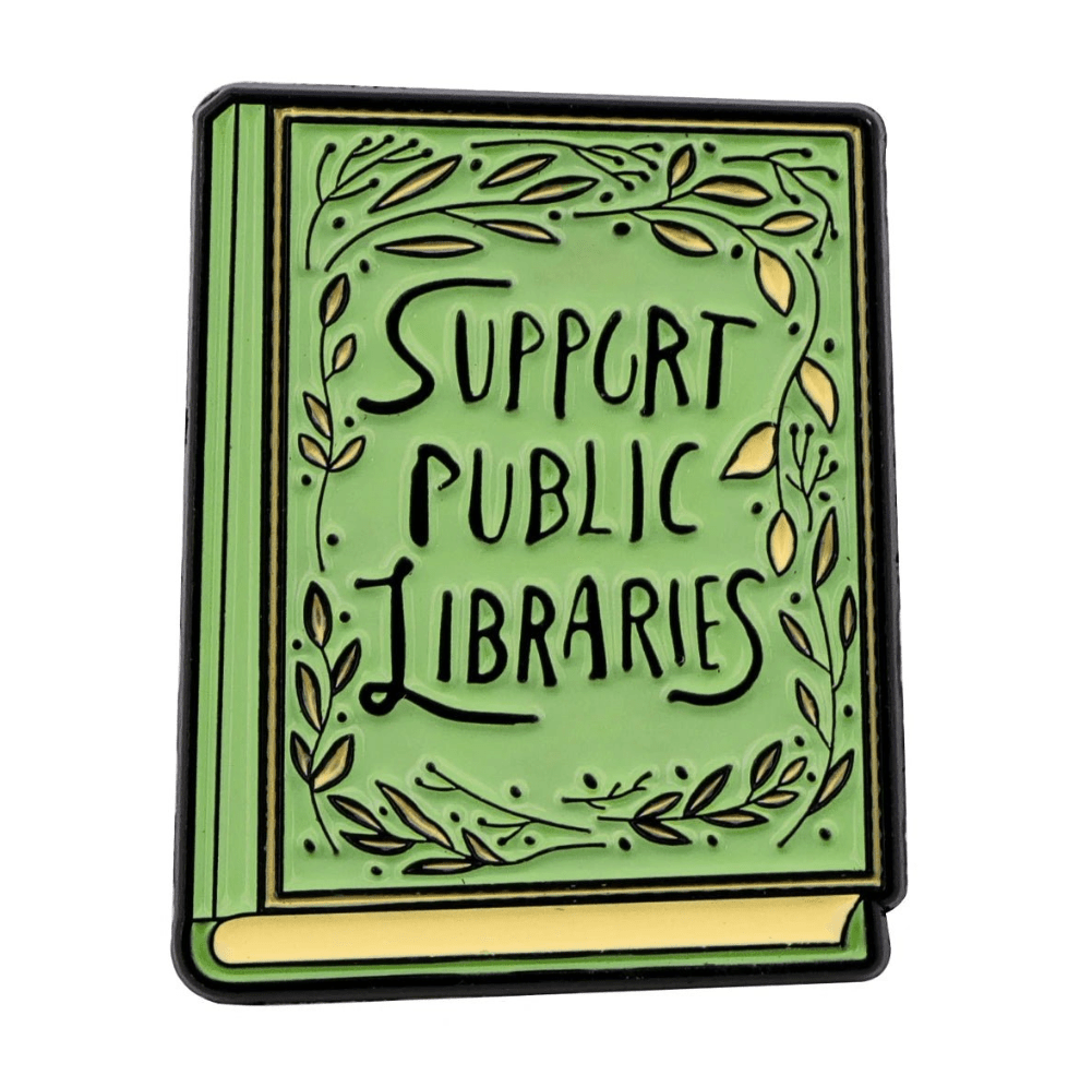 A green, book-shaped pin with yellow accents reads Support Public Libraries and is adorned with leafy vines—a perfect accessory for book fairs and public library enthusiasts.