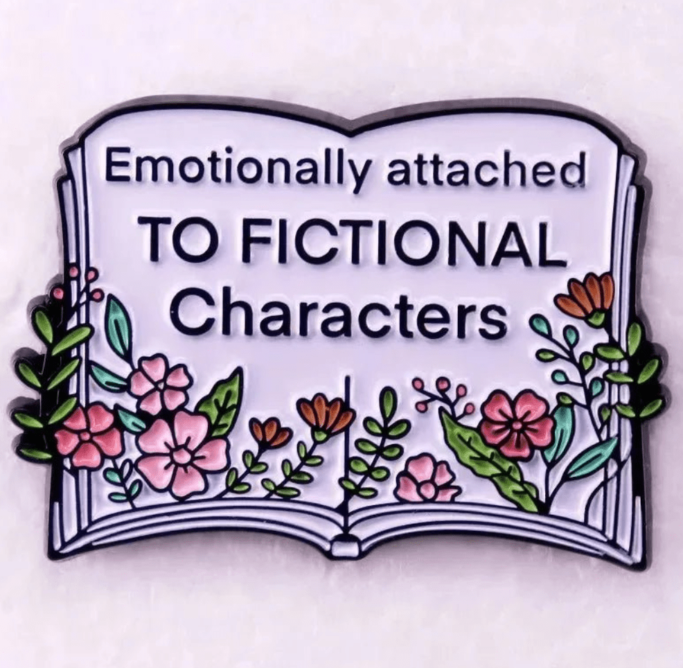 An illustration of an open book with colorful flowers and leaves, featuring “Emotionally attached TO FICTIONAL Characters” in bold text—a perfect  design for Romance Readers and book lover badges or enamel pins.