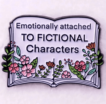 An illustration of an open book with colorful flowers and leaves, featuring “Emotionally attached TO FICTIONAL Characters” in bold text—a perfect  design for Romance Readers and book lover badges or enamel pins.