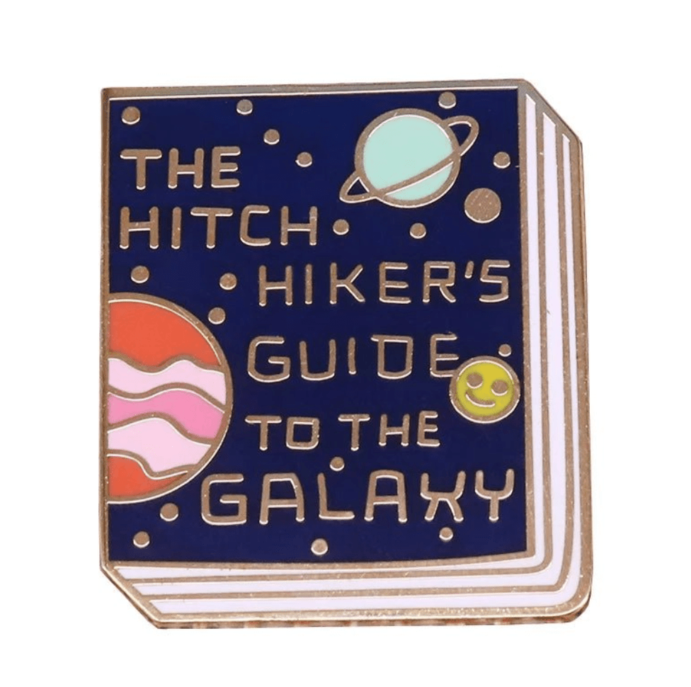 Enamel pin features The Hitchhiker’s Guide to the Galaxy book cover, with planets and a smiling green face on a dark blue background—a unique accessory for book lovers and badge collectors.