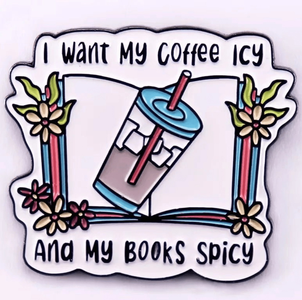 A colorful  illustration of an iced coffee with a straw on an open book with flowers. Features the text, I want my coffee icy and my books spicy. Perfect for romance readers, book lover badges, or enamel pins!.