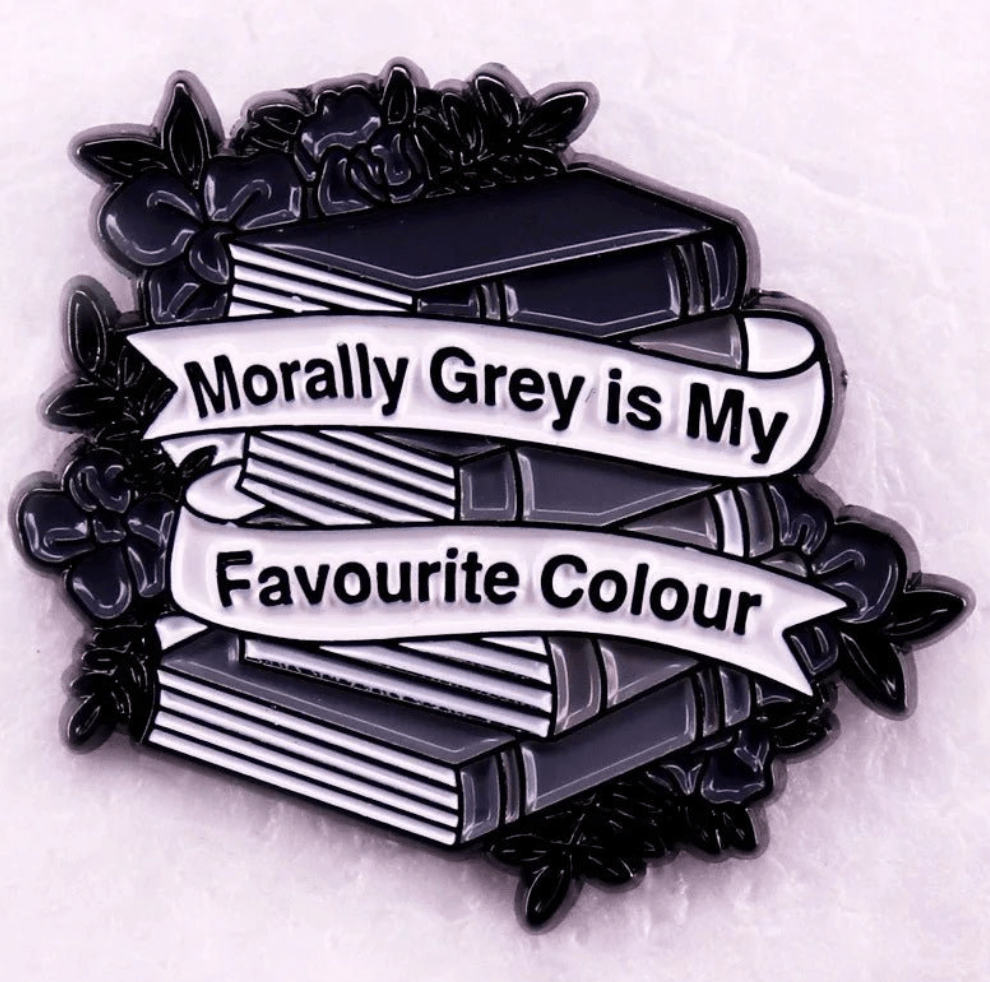 Enamel pin features stacked grey books with floral accents and a Morally Grey is My Favourite Colour banner—perfect for romance readers and book lover badge collections.