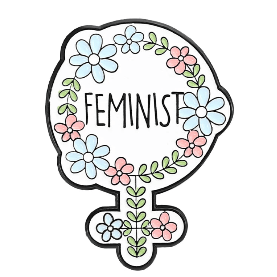 A feminine symbol outlined in black with blue and pink flowers plus green leaves forms a striking enamel pin, featuring the word FEMINIST in bold black letters at its center.
