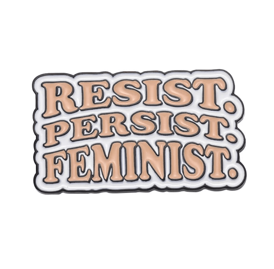 Enamel pin features peach text outlined in black that says RESIST. PERSIST. FEMINIST. on a white background—a bold, must-have accessory for any feminist pin collection.