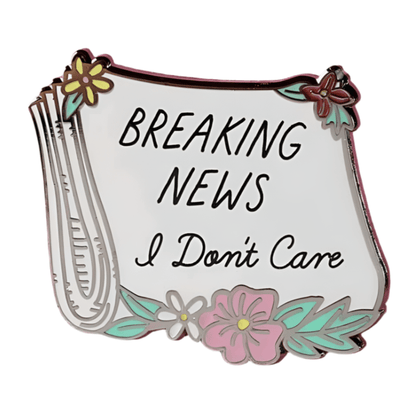 This My Cutesy Era enamel pin features a folded newspaper with flowers and bold BREAKING NEWS I Dont Care text in black on white, making it a decorative accessory with attitude.