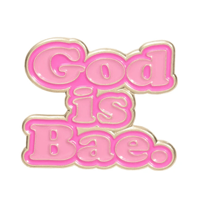 The Kiss Me Later pink enamel pin features God is Bae in bold bubble letters outlined in gold on a crisp white background.