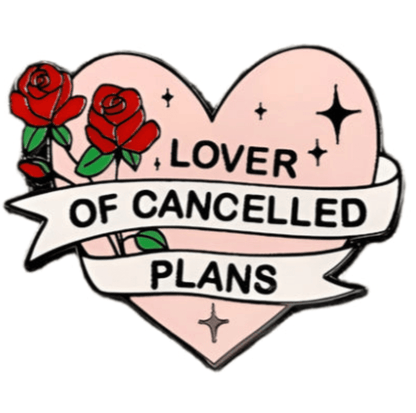 A Kiss Me Later pin shaped like a pink heart with two red roses and a white banner that says Lover of Cancelled Plans in bold black letters, featuring black star accents around the text.