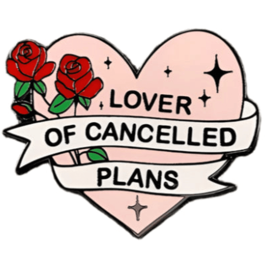 A Kiss Me Later pin shaped like a pink heart with two red roses and a white banner that says Lover of Cancelled Plans in bold black letters, featuring black star accents around the text.