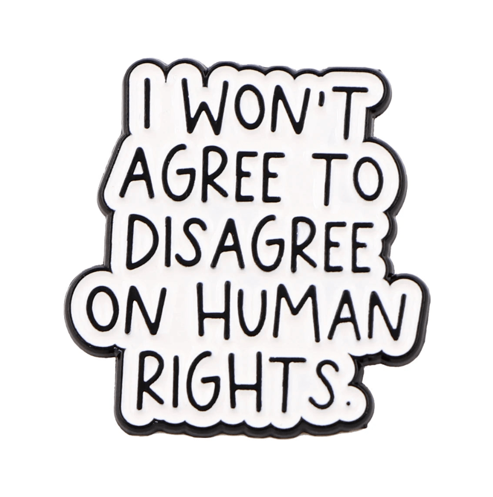 The Kiss Me Later enamel pin features bold black text on a white background that reads, I WONT AGREE TO DISAGREE ON HUMAN RIGHTS.