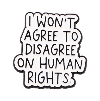 The Kiss Me Later enamel pin features bold black text on a white background that reads, I WONT AGREE TO DISAGREE ON HUMAN RIGHTS.