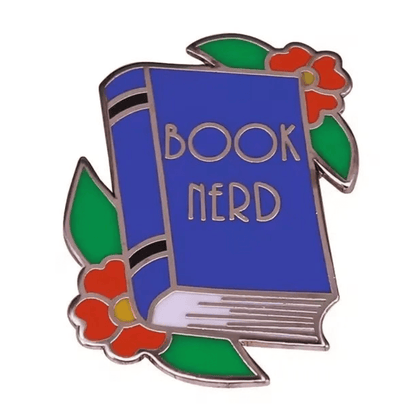 A blue enamel library pin shaped like a book with BOOK NERD on the cover, decorated with red flowers and green leaves perfect for book lover gifts or to add to your collection of book enamel pins.