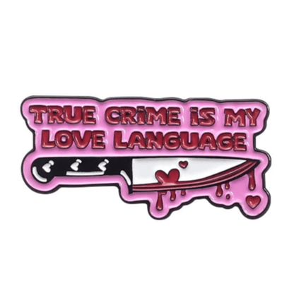A playful yet dark enamel pin by My Cutesy Era featuring pink TRUE CRIME IS MY LOVE LANGUAGE text above a bloody knife with dripping blood and hearts—perfect for any Dark Romance Book Club fan.