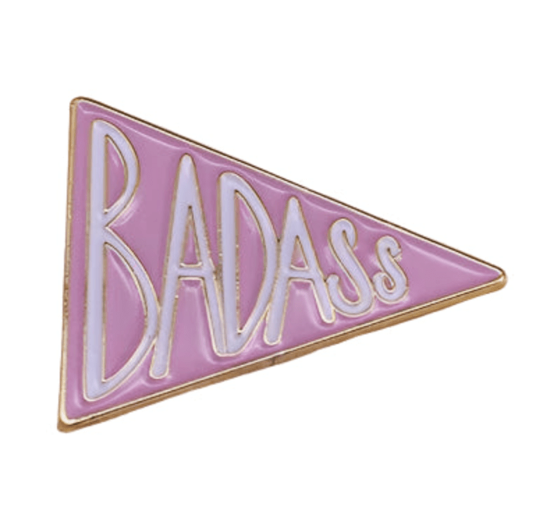 A Kiss Me Later pink triangular enamel pin with gold borders and BADASS in bold white and gold letters—perfect for those who know well-behaved women rarely make history.