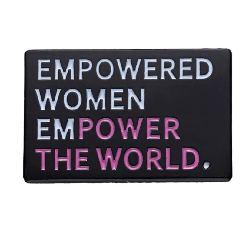 My Cutesy Era’s black rectangular pin features the phrase “EMPOWERED WOMEN EMPOWER THE WORLD,” with “EMPOWER” in pink, inspired by Well Behaved Women Rarely Make History.