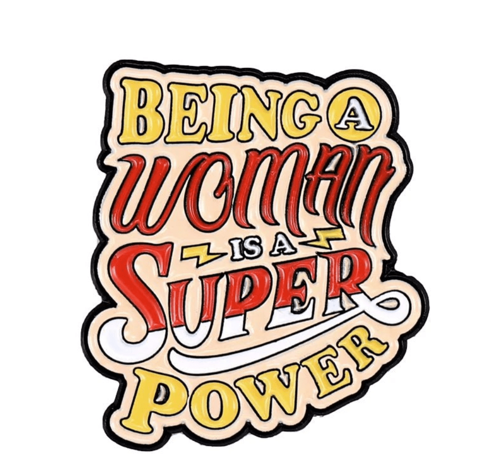 A hand-lettered My Cutesy Era design reads Being a Woman is a Super Power, with woman and super in bold red, and other words in yellow and black on cream—a perfect motivational enamel pin for every strong, body-positive spirit.