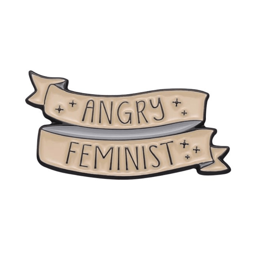 A beige ribbon banner pin by My Cutesy Era features the inspirational quote “ANGRY FEMINIST” in bold black uppercase letters, accented with small star-like designs.