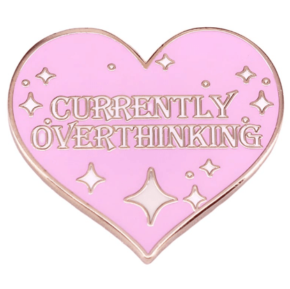 A pink heart enamel pin by My Cutesy Era features CURRENTLY OVERTHINKING in capitals, with small sparkle and star accents.