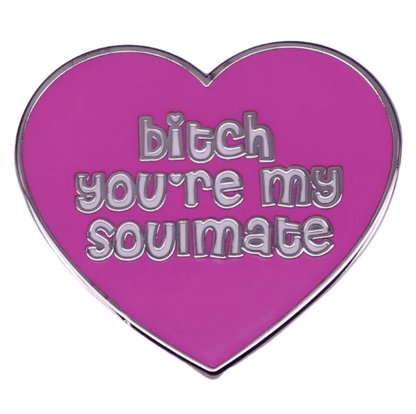 The My Cutesy Era pink heart enamel pin features silver edges and the phrase “bitch you’re my soulmate” in fun silver lettering.