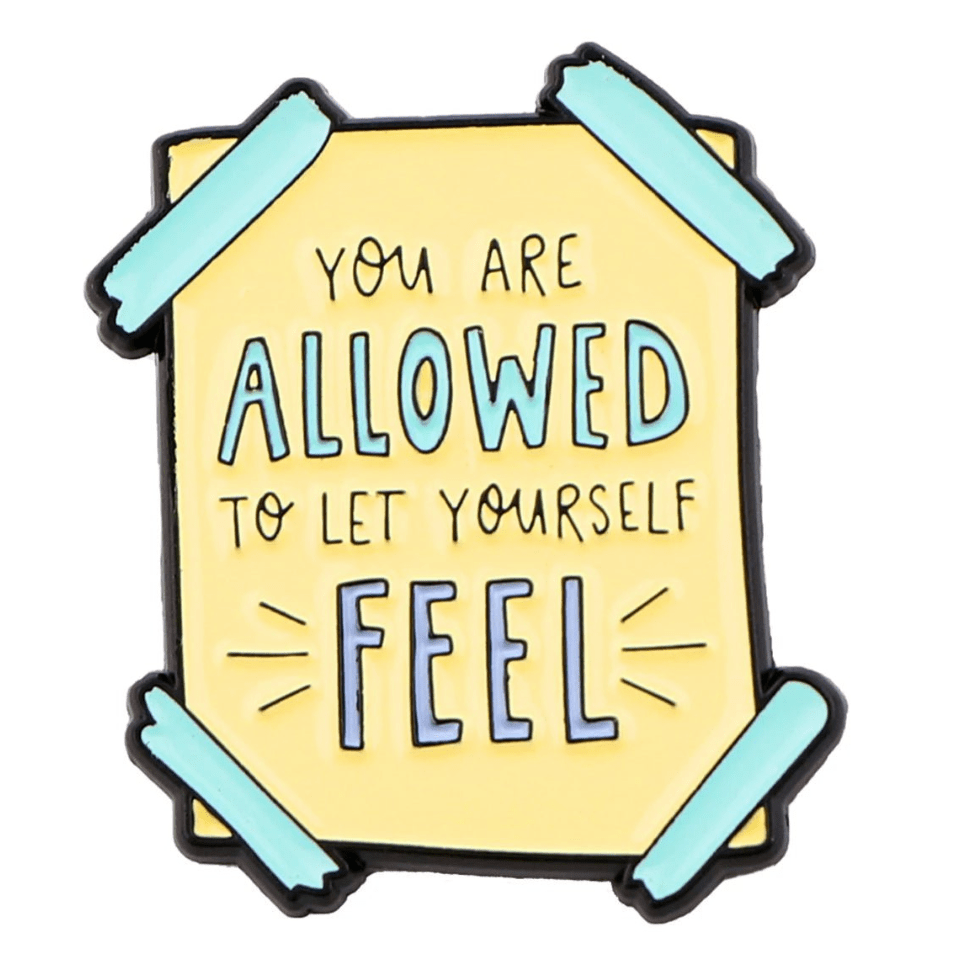 A yellow sign from My Cutesy Era with teal tape on the corners reads You are allowed to let yourself feel, featuring allowed and feel in larger blue letters—a motivational reminder supporting mental health.