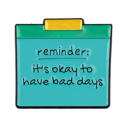 A My Cutesy Era teal note, pinned with yellow tape, features a handwritten black motivational message—reminder: its okay to have bad days—on a white background.