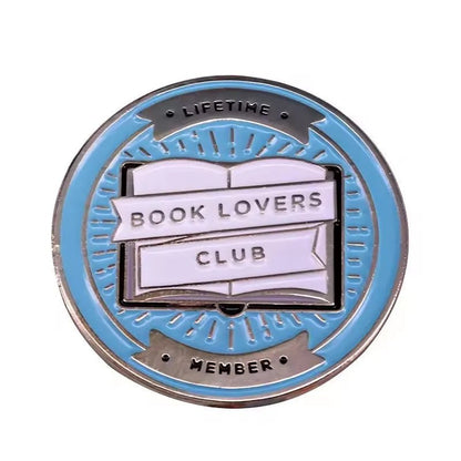 Add to your collection with this My Cutesy Era round blue and silver enamel pin. Featuring an open book with “BOOK LOVERS CLUB” and “LIFETIME MEMBER” around the edge, it’s perfect for every devoted reader.