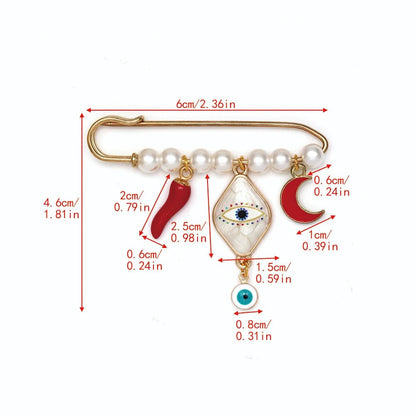 The Kiss Me Later gold evil eye pin brooch, with white beads and four charms (red chili, blue eye, red crescent, and evil eye), features red measurement lines—making it a unique baby shower gift.