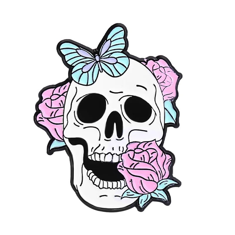 A white skull with black eye sockets features pink roses, a light blue butterfly, and a whimsical pink cat pin, artistically blending life and death on a plain white background.