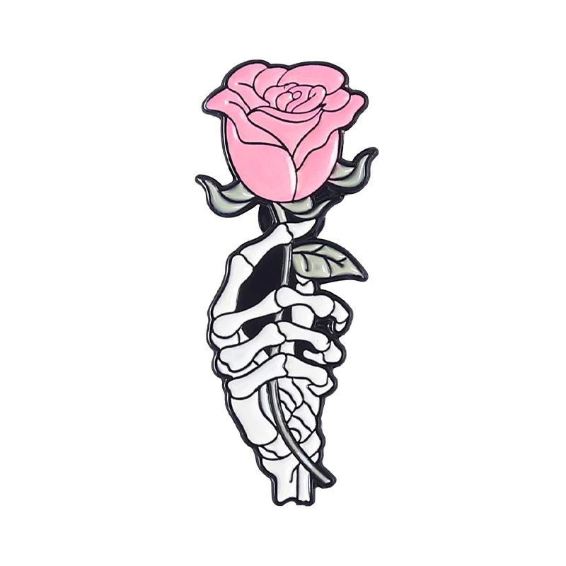 A stylized drawing of a skeletal hand clutching a pink rose with green leaves on a white background, inspired by the edgy style seen in skull enamel pins.