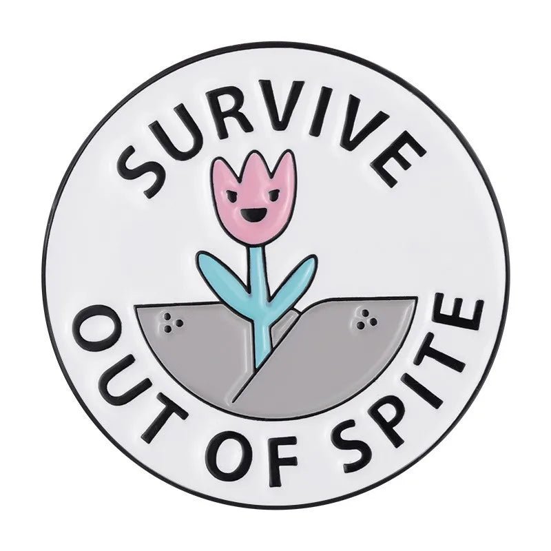 A  round enamel pin shows a smiling pink flower sprouting from a gray crack, with SURVIVE OUT OF SPITE in bold black letters on white. An inspiring accessory for anyone who perseveres against the odds.