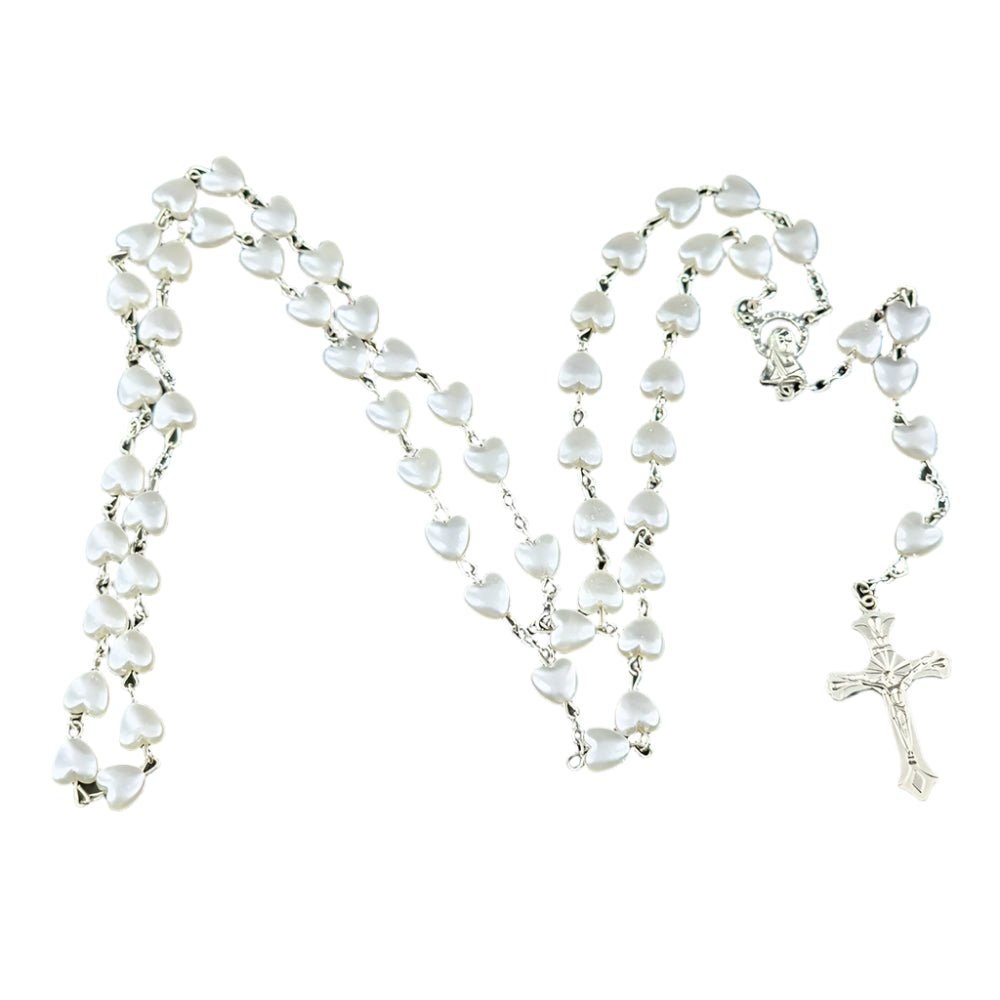 A My Cutesy Era rosary necklace with white heart-shaped beads linked together and a silver crucifix at the end, displayed in a loose, wavy pattern on a white background.