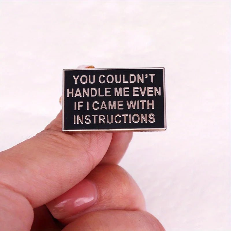 A hand holds a black rectangular badge by My Cutesy Era 
with white text reading, YOU COULDNT HANDLE ME EVEN IF I CAME WITH INSTRUCTIONS. The plain white background highlights this humorous accessory.