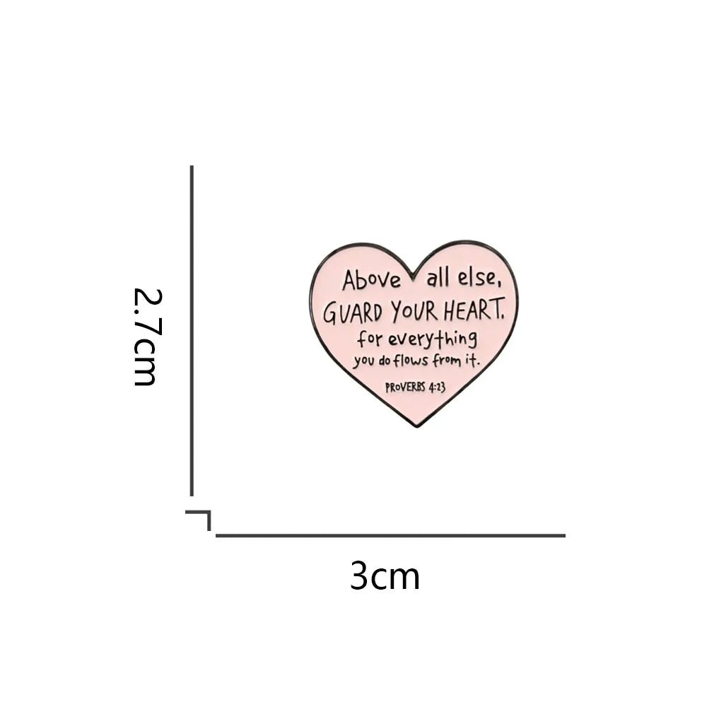 Kiss Me Laters pink love heart enamel pin sticker features the text Above all else, GUARD YOUR HEART. For everything you do flows from it. PROVERBS 4:23. The heart measures 2.7 cm tall by 3 cm wide.