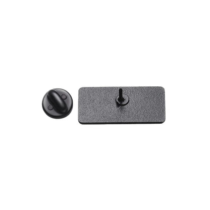 A rectangular, textured black plate with a central peg is displayed next to a round, flat black knob on a white background—both resemble the backings of Holy Spirit or God All Things Are Possible pins.