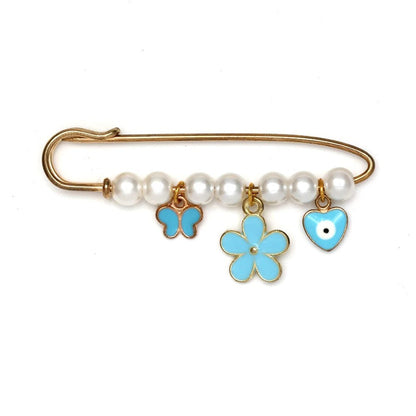Kiss Me Laters gold safety pin features white beads and three blue charms—a butterfly, a flower, and an evil eye heart—making it a unique beads and charms brooch or thoughtful baby shower gift.