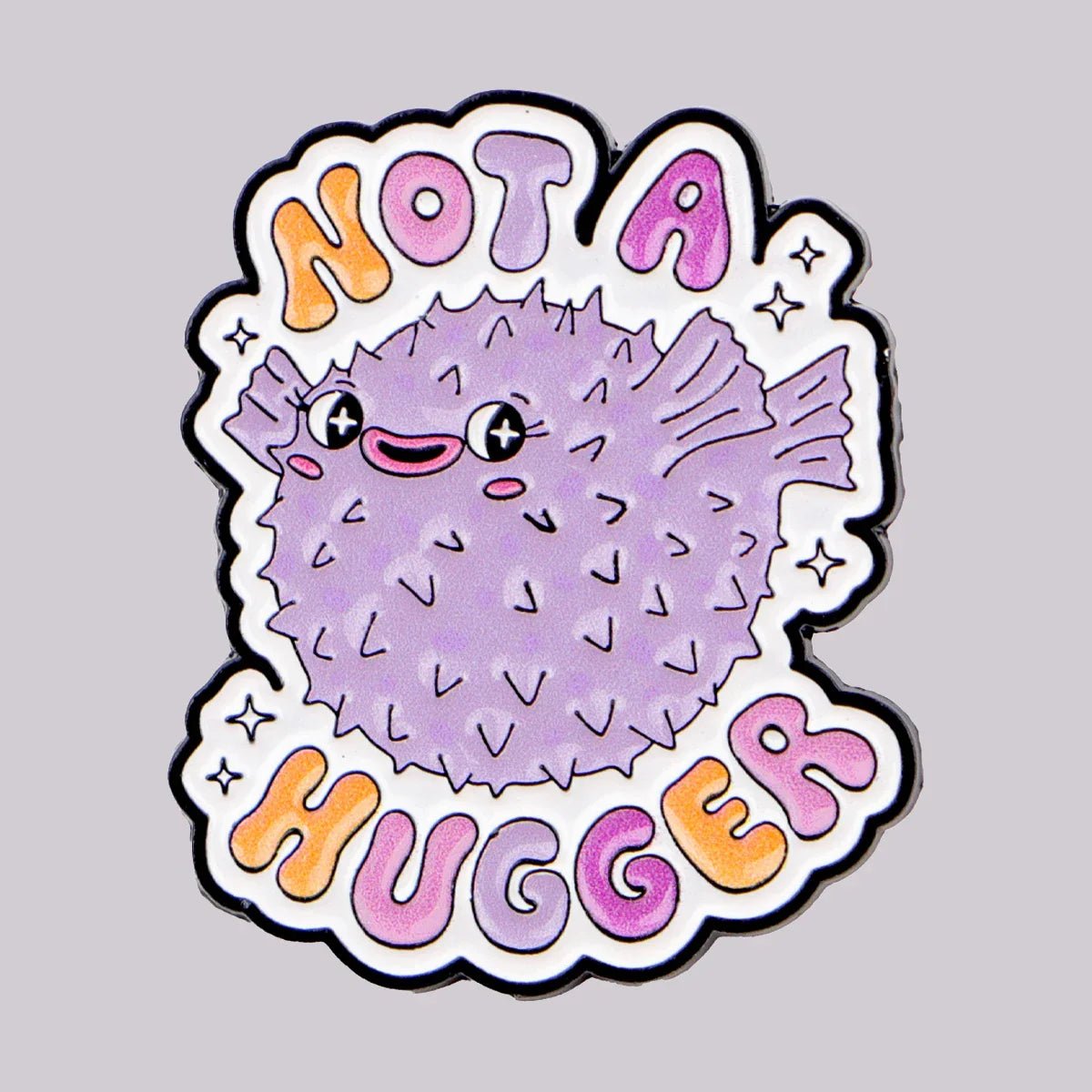 A cute, cartoon-style purple pufferfish pin with a smiling face and spikes, surrounded by Not A Hugger in colorful letters on white—a fun pride accessory or enamel pin by Gay Skate.