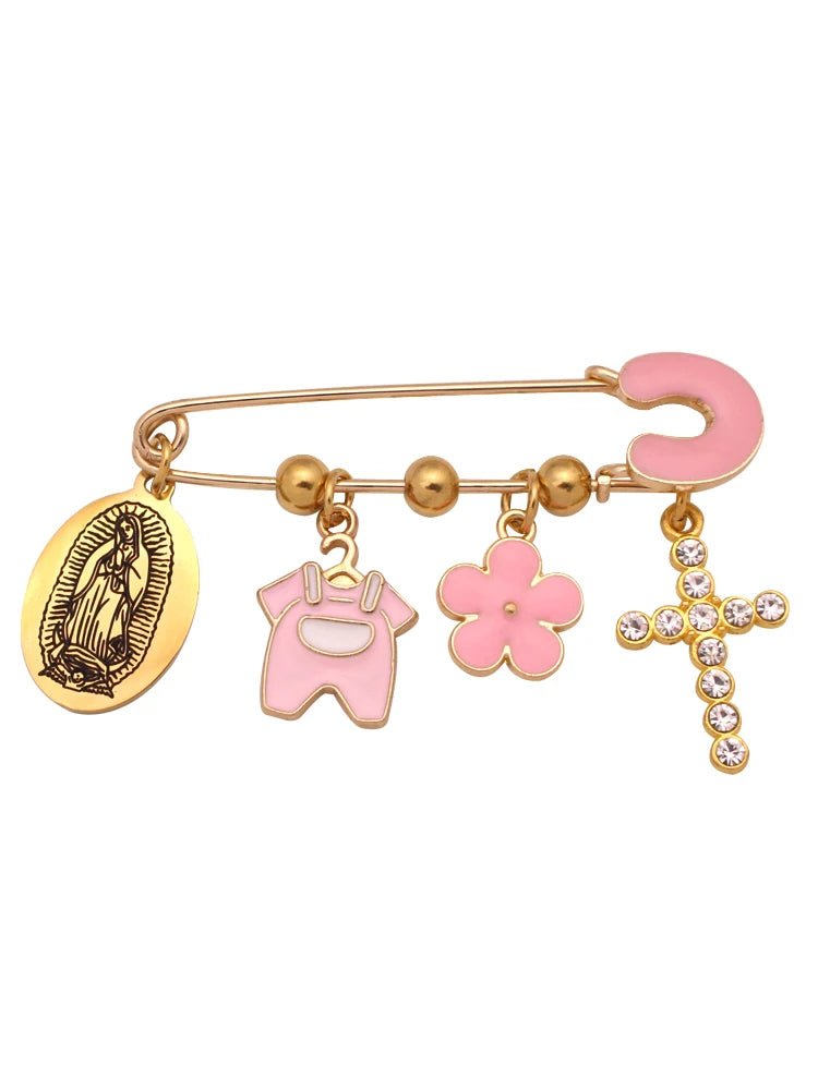 A Kiss Me Later gold Christian baby pin brooch features four charms—a Virgin Mary medallion, pink onesie, pink flower, rhinestone cross—and includes a pink horseshoe at the end.