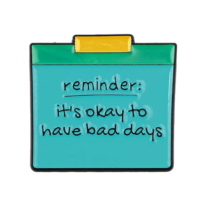 A teal sticky note with a yellow top reads reminder: its okay to have bad days in handwritten-style black text, providing a gentle mental health affirmation.