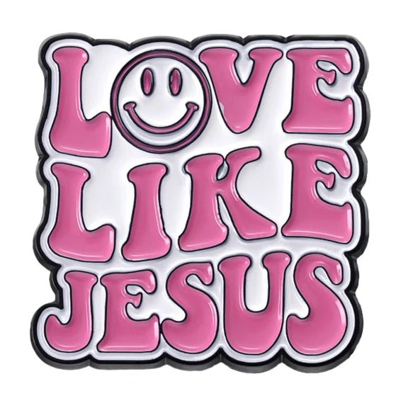 Text in bold, retro pink letters reads “Love Like Jesus,” with the “O” as a smiley face. This playful pin pops on white—perfect to wear or gift as a cheerful pink enamel Jesus accessory.