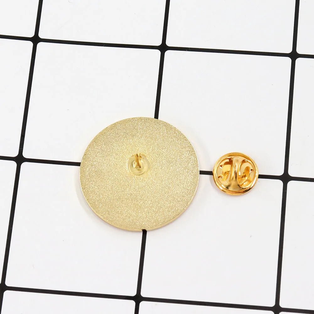 A 3cm x 3cm round gold lapel pin faces down beside its detached butterfly clutch on a white grid background with black lines.