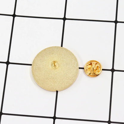 A 3cm x 3cm round gold lapel pin faces down beside its detached butterfly clutch on a white grid background with black lines.