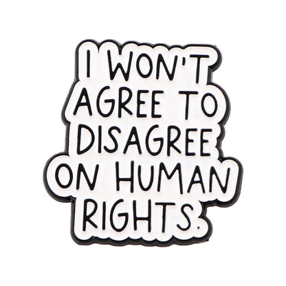 A My Cutesy Era enamel pin featuring black text on a white background that says I WONT AGREE TO DISAGREE ON HUMAN RIGHTS.