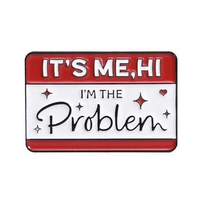 This My Cutesy Era enamel pin features a rectangular design with a red top saying ITS ME, HI and a white bottom saying IM THE Problem, accented by small red sparkles and hearts around the text.