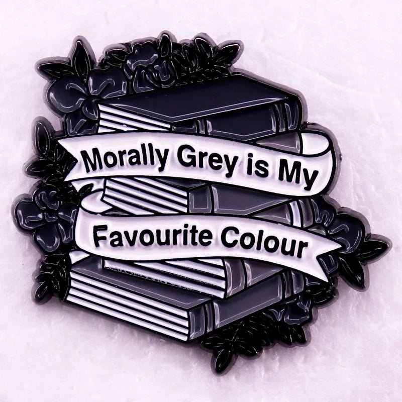 Enamel pin for romance readers and badge collectors, featuring stacked grey books with black flowers and banners that say Morally Grey is My Favourite Colour in black text.