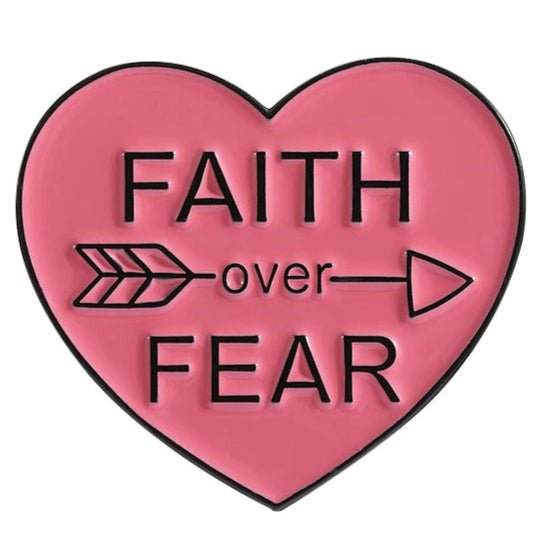 Show your Faith Over Fear with this red pink heart-shaped enamel pin featuring a black FAITH Over FEAR design and an arrow pointing right through over.
