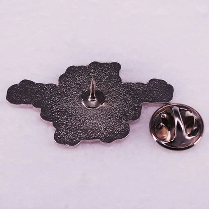 Pink and silver enamel pin with a textured back and single pointed post is displayed next to its round butterfly clutch clasp on a light surface.