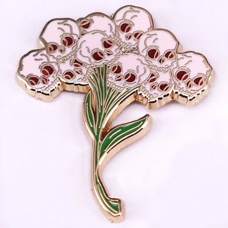 A decorative accessory shaped like a Gothic Bouquet, with pink skull blossoms and gold and green stems and leaves, all set on a white background.